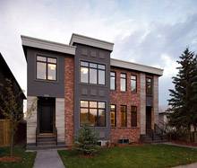 фасад двухэтажного дома. сочетание штукатурки серого цвета, красного клинкера и травертина